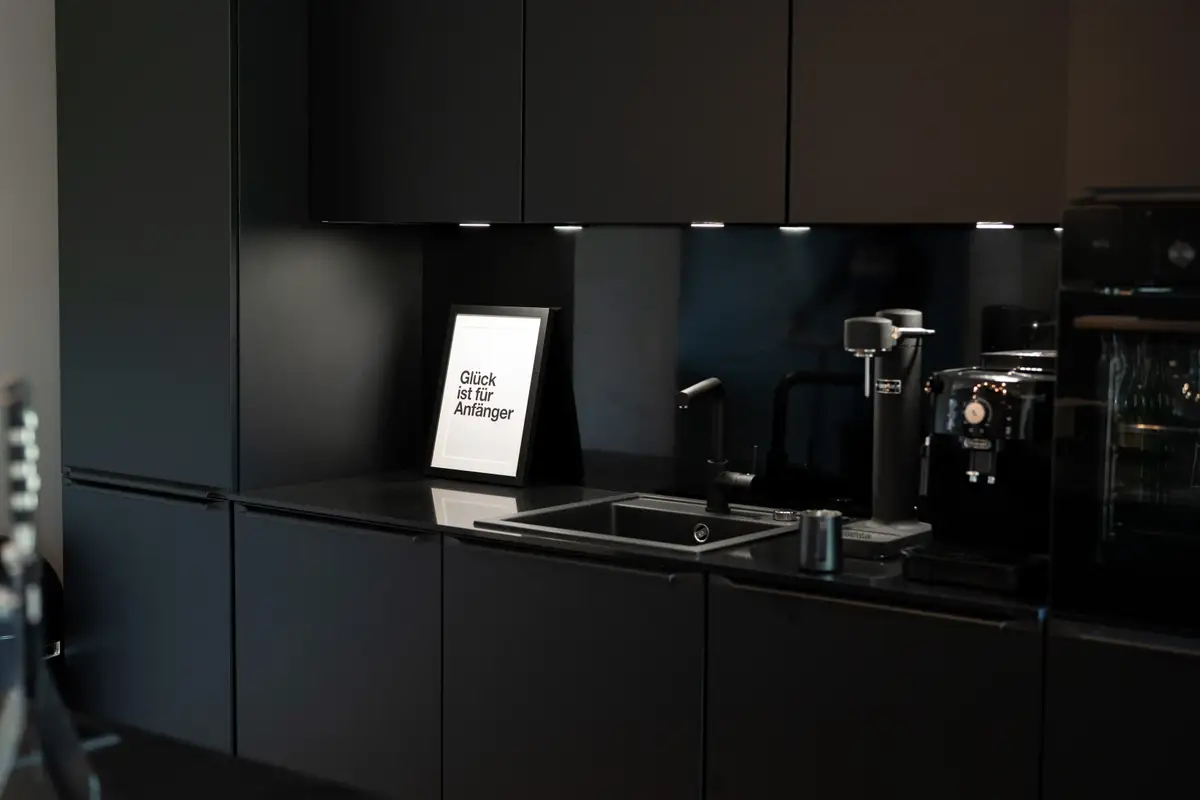 Designküche im Unternehmer-Quartier mit Bild „Glück ist für Anfänger"